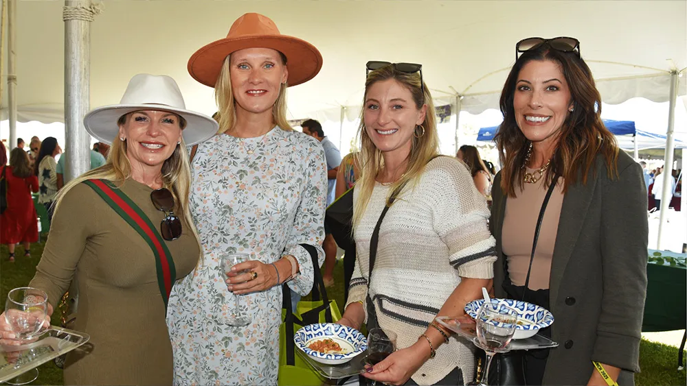 Four women enjoying food and drinks at Suncoast Food & Wine Fest