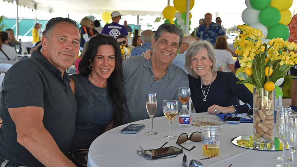 Four attendees smiling at a VIP table at the Suncoast Food & Wine Fest.