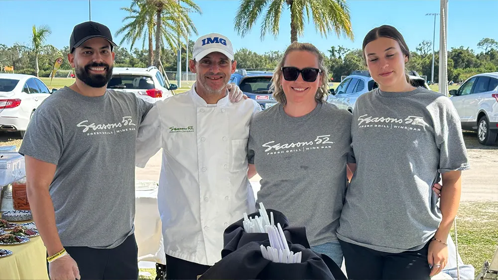 Seasons 52 team posing at their booth at Suncoast Food & Wine Fest